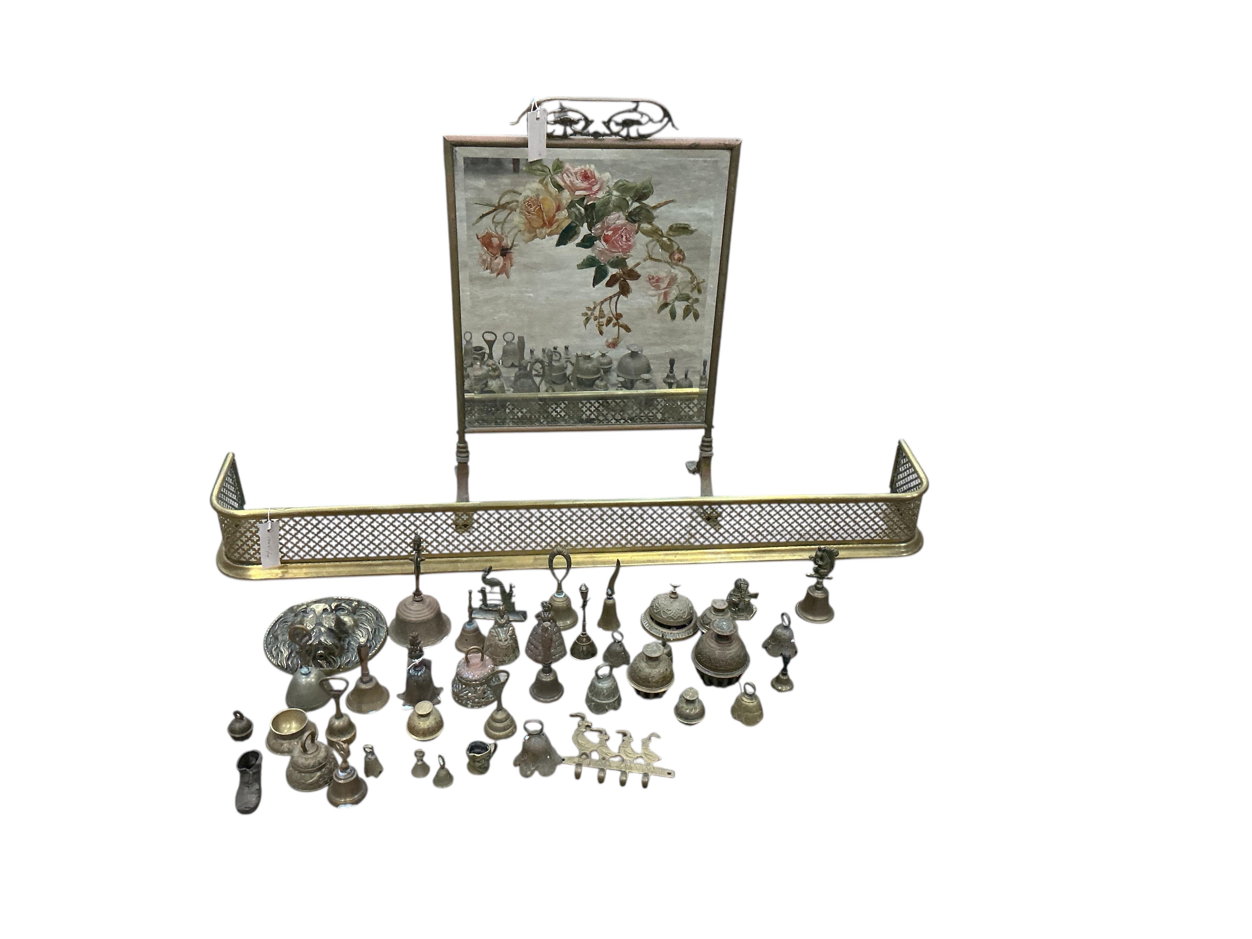 A late Victorian mirrored brass fire screen, height 70cm, together with a brass fender, ornamental brass and a leather bucket